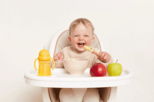 śmiejące się dziecko w trakcie posiłku