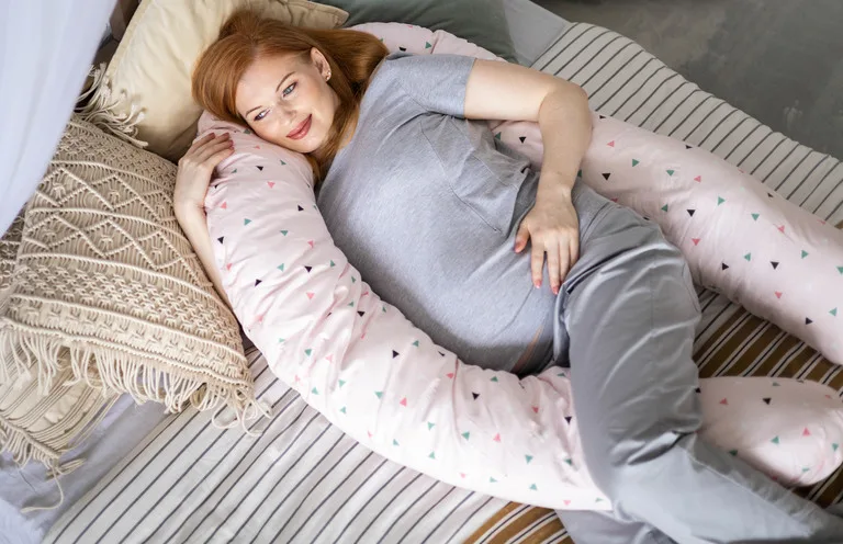 Kobieta w ciąży z poduszką dla kobiet w ciąży